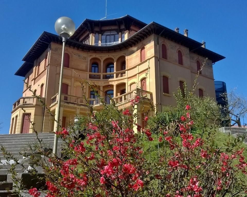 veduta dal basso della facciata della villa con glicine in fiore