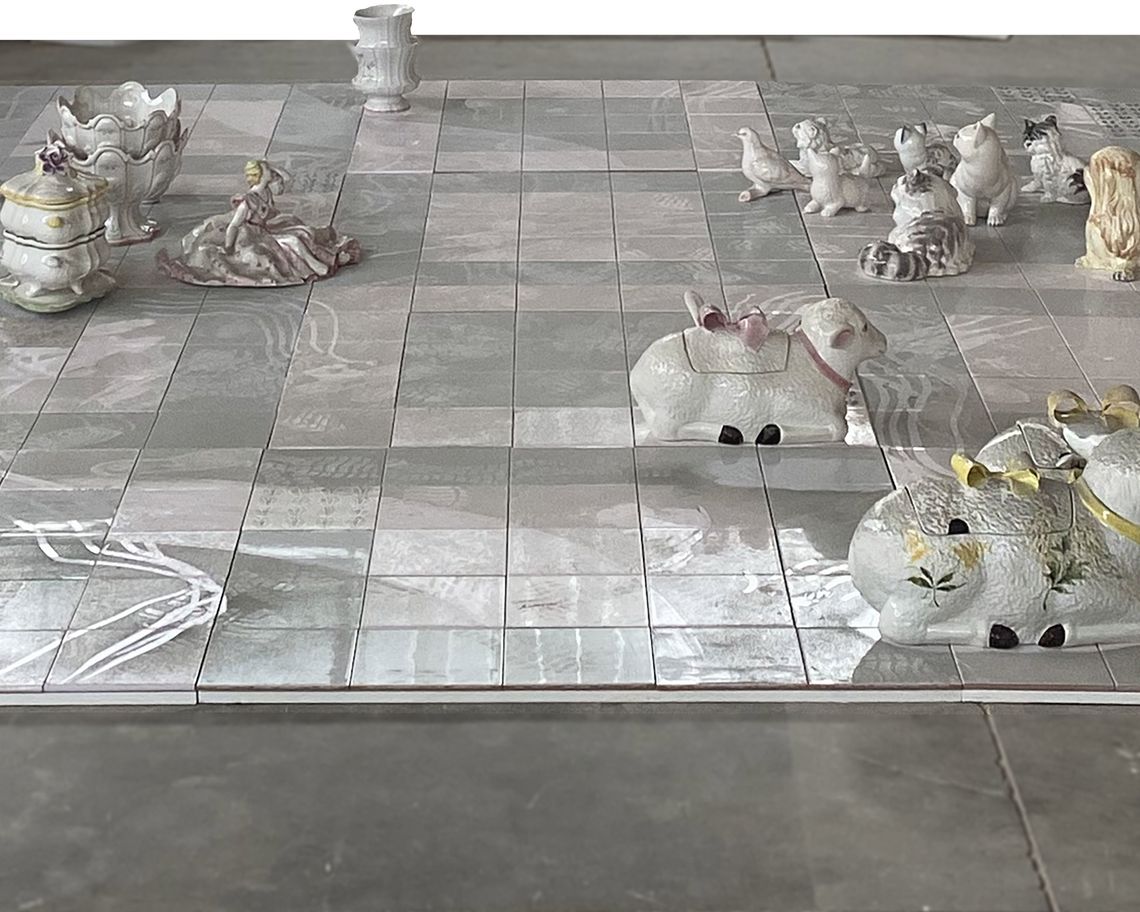 installazione con sculture di ceramica e legno su pavimento a quadrati