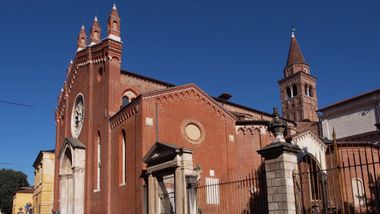 Esterno dell'edificio in muratura rossa con cancellata del giardino esterno