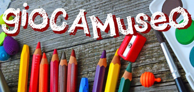 In alto scritta "Gioca museo", sullo sfondo sono presenti pastelli colorati, un temperamatite, un pennello e degli acquerelli.