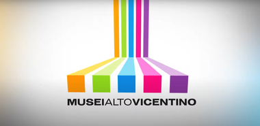 Sfondo bianco con la scritta nera "Musei Altovicentino" e in alto cinque bande colorate.