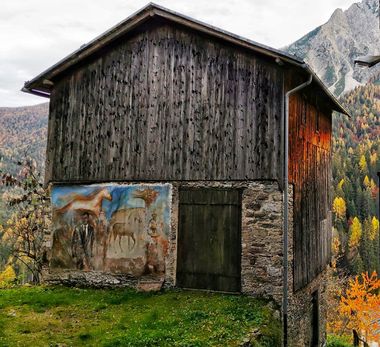 Paesaggio montano e murale su casa di legno con cavalli