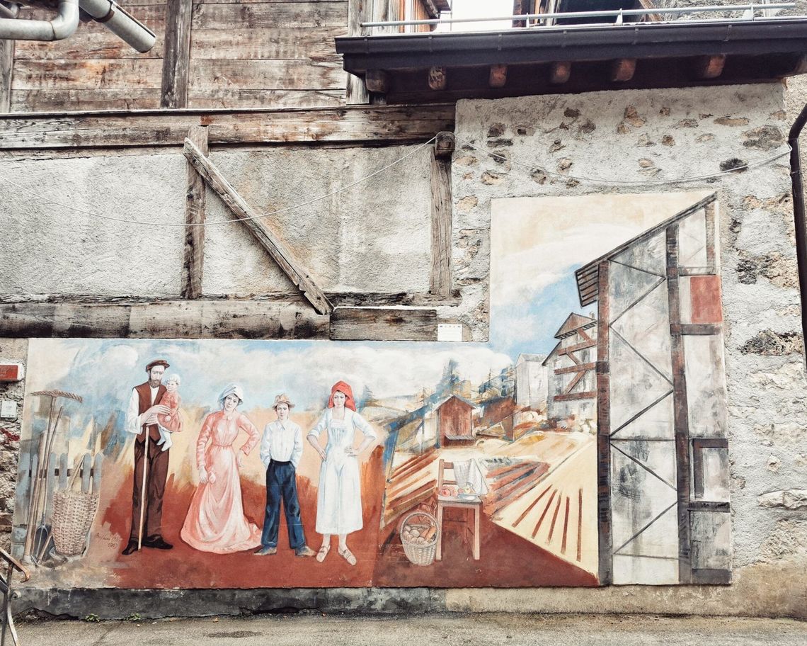 Murale di una famiglia di contadini (padre, madre, bambina e due figli) con la loro casa, il campo e gli attrezzi