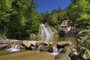 Veduta del mulinetto di Refrontolo immerso nel verde. In primo piano il laghetto creato dalla cascata.
