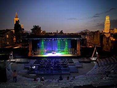 Vista serale estiva del palco teatrale all'aperto  da un'altra prospettiva