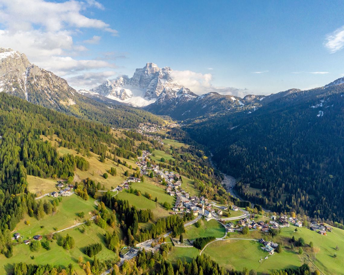 veduta aerea del Comune di Selva di Cadore tra i prati con strada principale