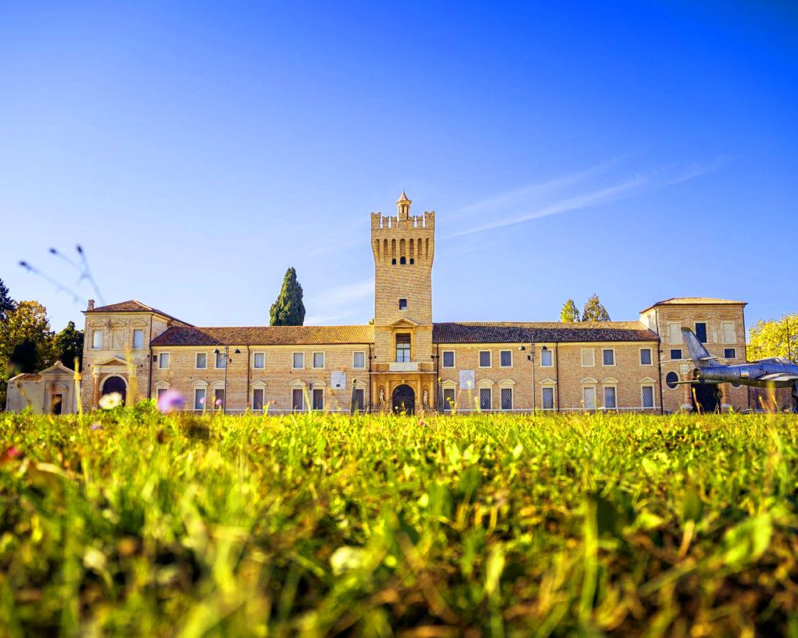 facciata del Castello di San Pelagio con vista sul campo di aviazione e areo storico