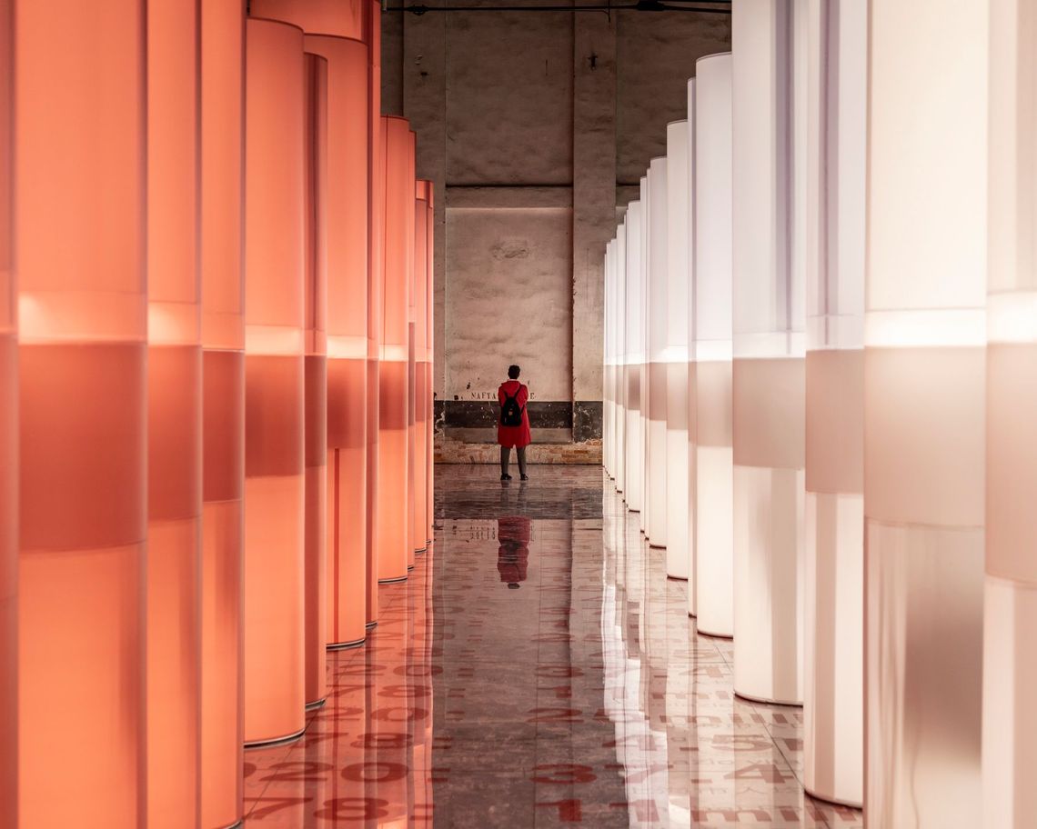 istallazione con colonne luminose arancioni e bianche