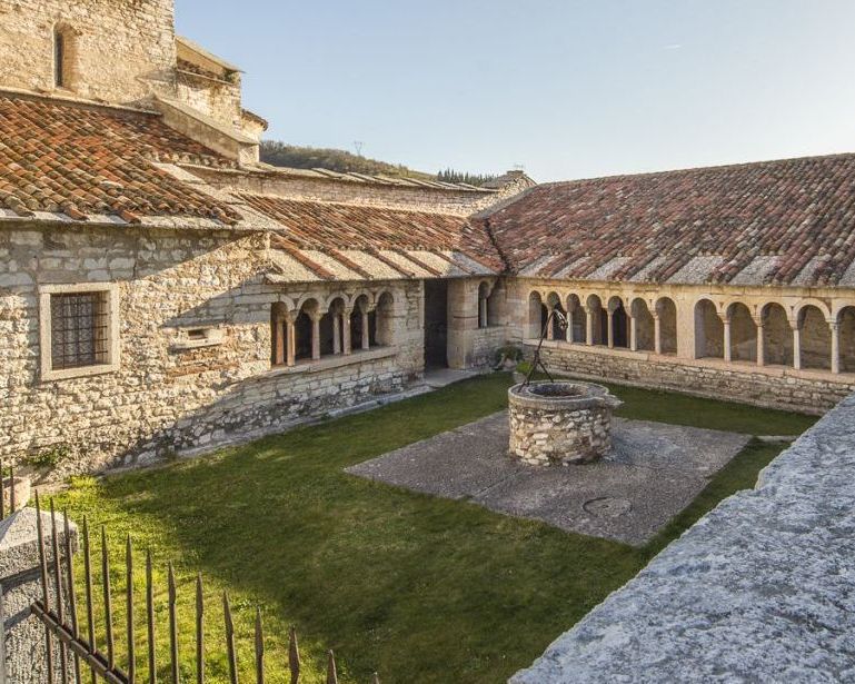 chiostro della pieve con porticato e pozzo al centro del giardino
