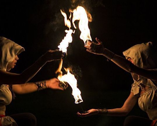 Scena notturna con figurante in costume e giochi con il fuoco