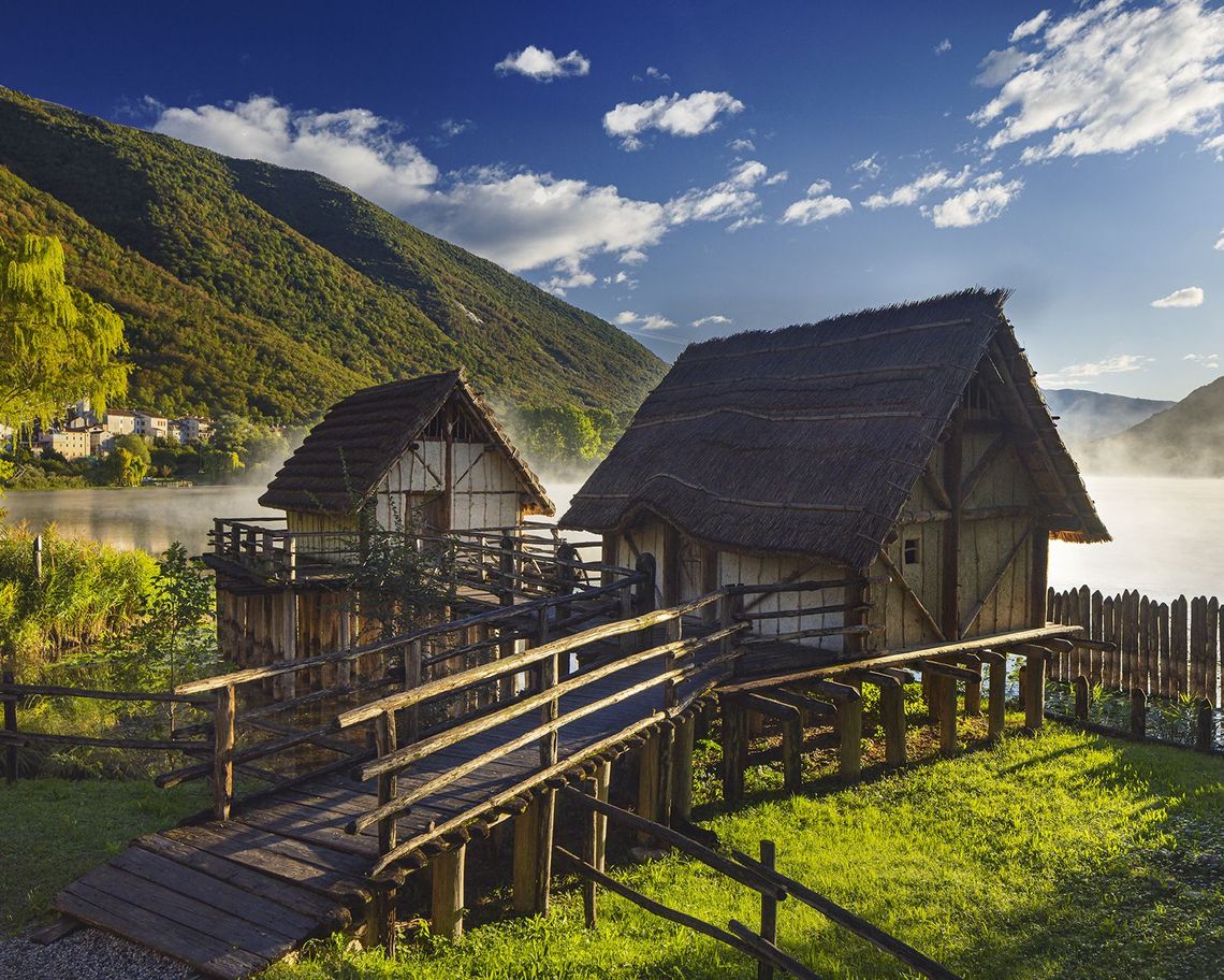Due palafitte rialzate sull'erba in riva al lago