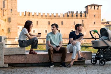 Silvia D'Amico, Lino Guanciale e Diego Facciotti, seduti su un muretto davanti al Castello
