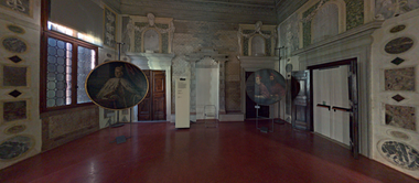 Interno di una sala di Palazzo Grimani, caratterizzata da soffitti decorati e pareti affrescate. Due ritratti sono appesi alle pareti.