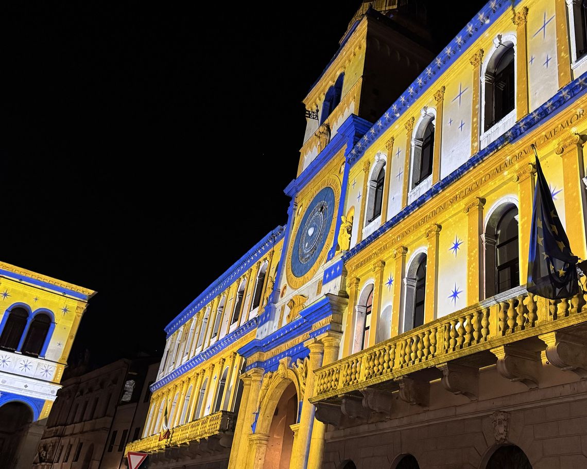 Palazzo con torre dell'orologio visto in diagonale con proiezioni giallo blu
