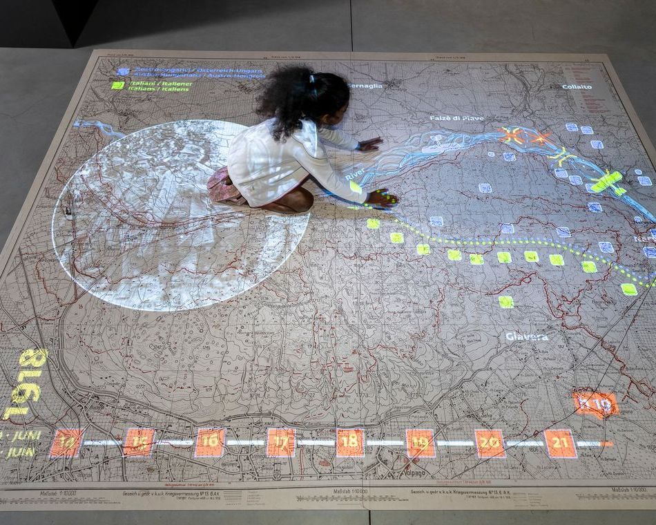 bambina inginocchiata su un pannello geografico interattivo