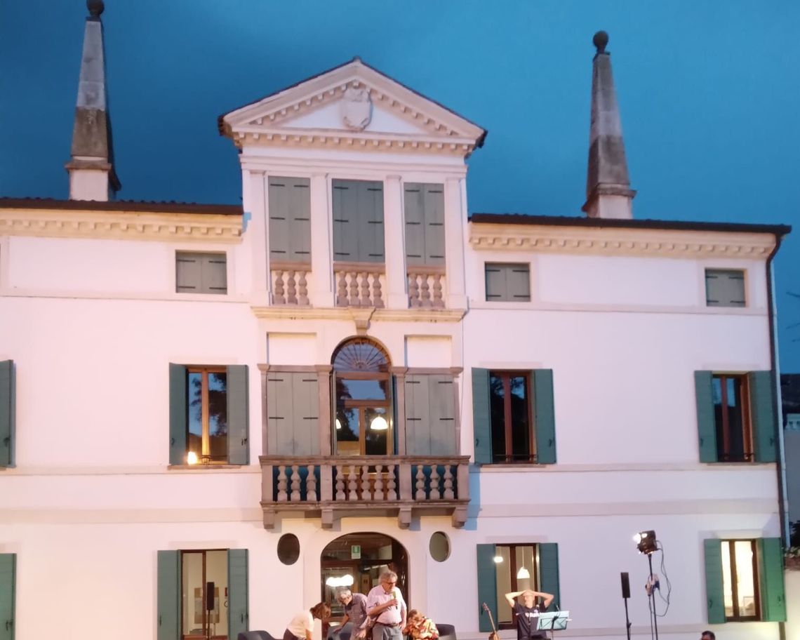 Facciata della villa con pubblico all'esterno durante una serata evento