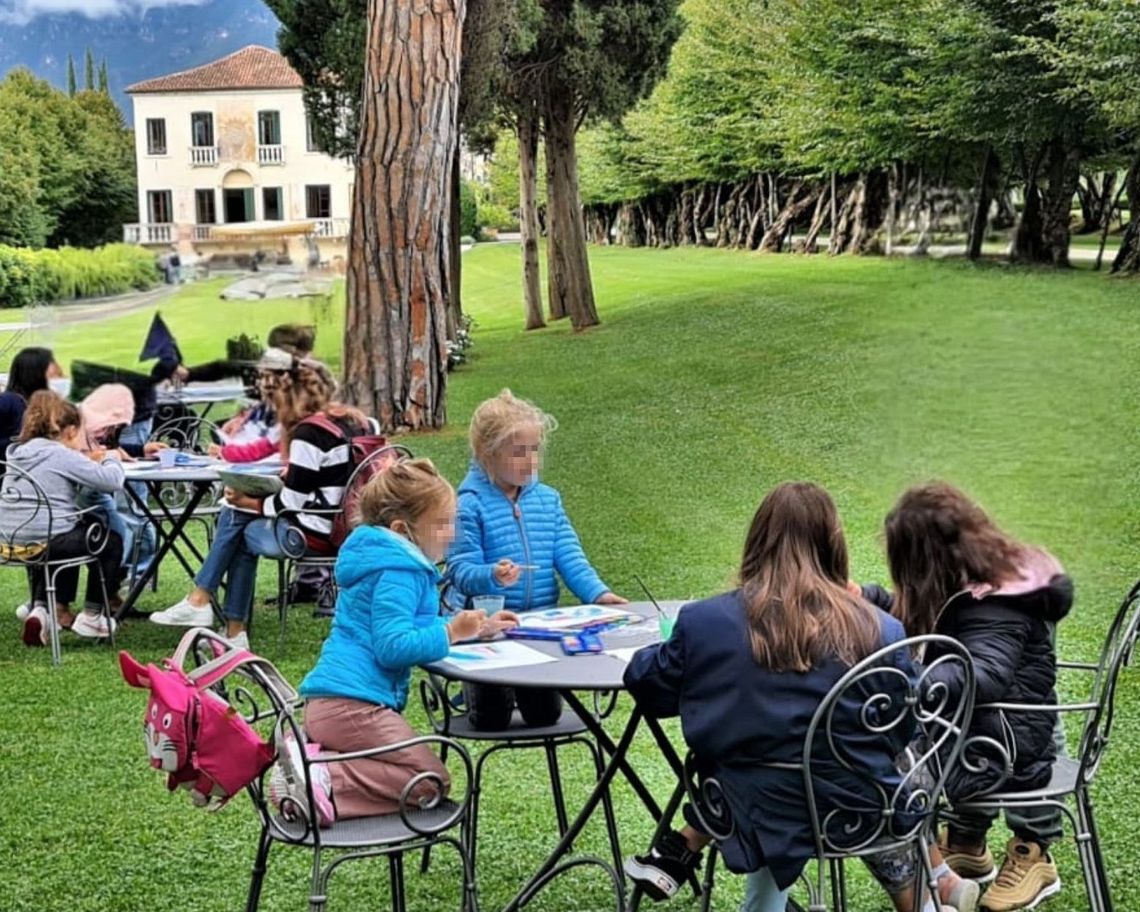 bambini ai tavolini nel giardino della villa