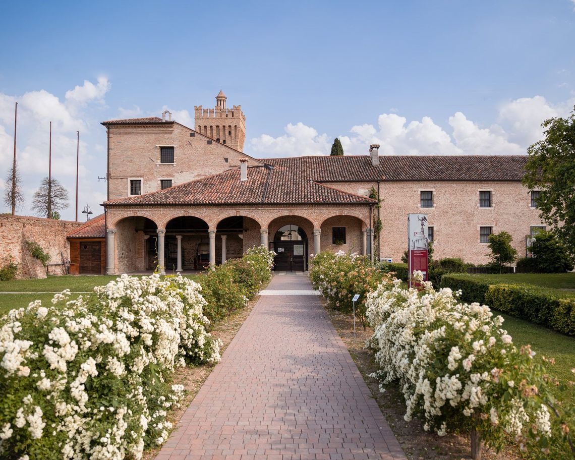 barchessa con porticato vista dal giardino con viale e rose ai lati