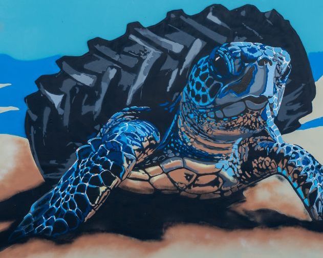 Tartaruga nero azzurra che esce dal mare con un pneumatico al posto del carapace