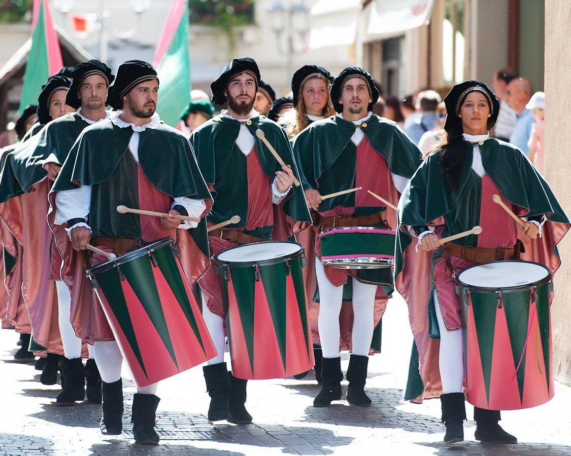 Gruppo bandistico e tamburi vestiti con abiti trecenteschi dal colore rosso e verde, sfilano per le strade di Monselice