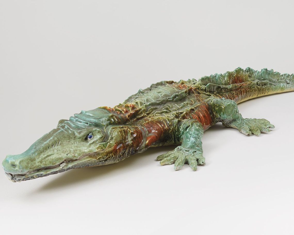 Coccodrillo disteso verde con parti arancione