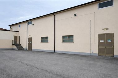 Foto dell'esterno del cineteatro santa sofia di canaro, con la facciata spoglia e semplice in cemento e due porte grigie d'ingresso, stile industriale.