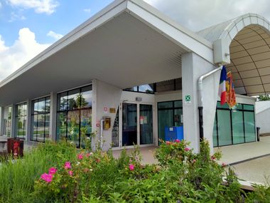 Esterno della biblioteca in edificio moderno bianco con grandi vetrate e un'arca di ingresso a volta