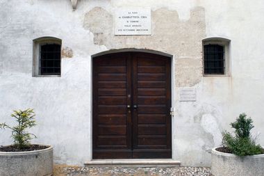 Facciata esterna in muratura bianca con portone centrale in legno e due piccole finestrine laterali: nel selciato a destra e sinistra della porta due fioriere in marmo. Sopra la porta insegna con indicazione della Casa.