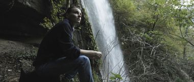 Maria Roveran seduta accanto ad una cascata